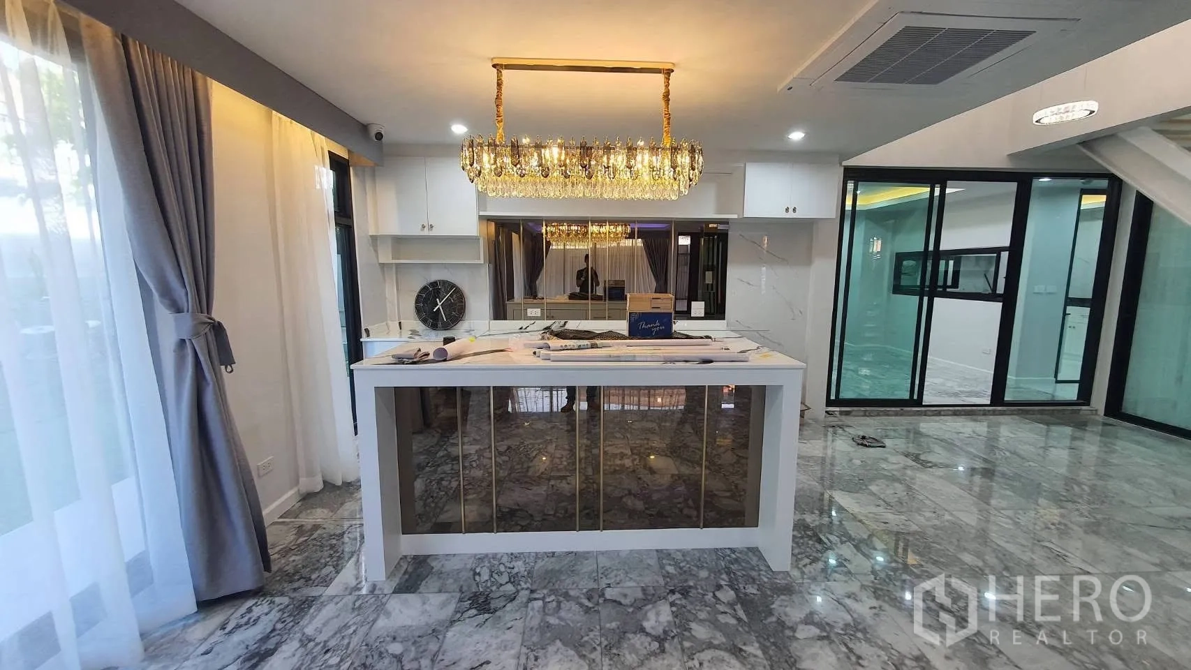 Detached House for rent in Lat Phrao, Bangkok - Spacious lounge with marble floors, shelving and large windows.