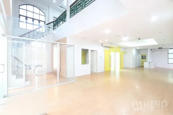 办公空间 出租在Bang Na, Bangkok - 挑高大堂与工作区，楼梯、玻璃门与空调，适合设接待区。