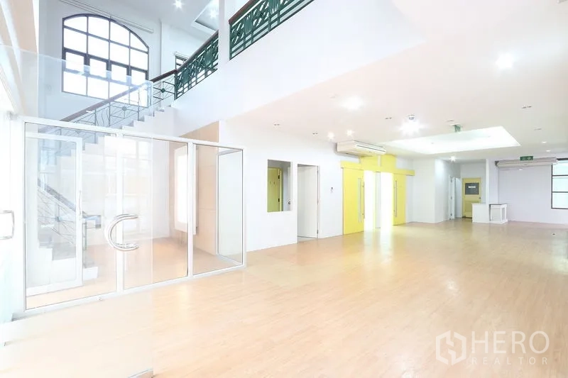 办公空间 出租在Bang Na, Bangkok - 挑高大堂与工作区，楼梯、玻璃门与空调，适合设接待区。
