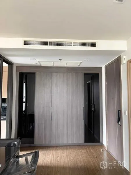 公寓 出售在Watthana, Bangkok - 入口走廊，内置衣柜、木地板与隐藏式中央空调。