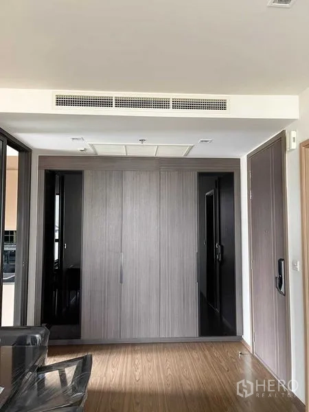 公寓 出售在Watthana, Bangkok - 入口走廊，内置衣柜、木地板与隐藏式中央空调。