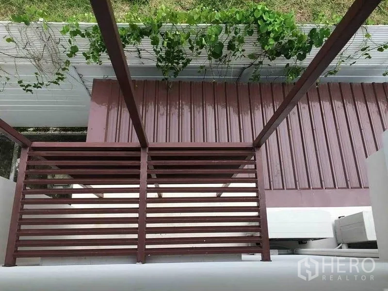 ทาวน์เฮาส์ ขายในSuan Luang, Bangkok - มุมมองระเบียงและกันสาดโลหะ พร้อมแนวไม้เลื้อยริมกำแพง