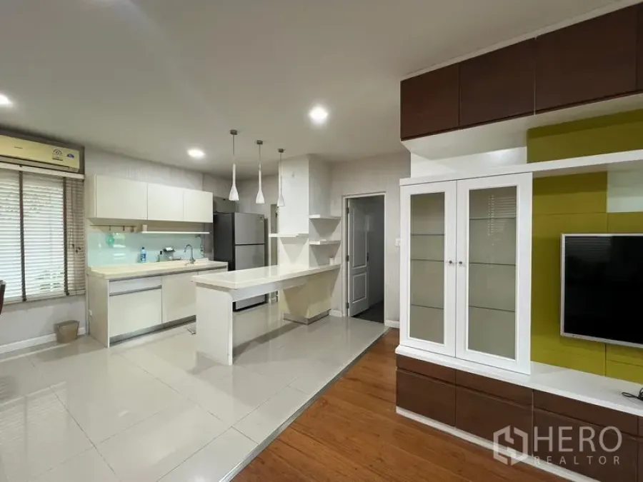 Detached House for rent in Bang Kapi, Bangkok - Open-plan kitchen and living area with TV unit and breakfast island.