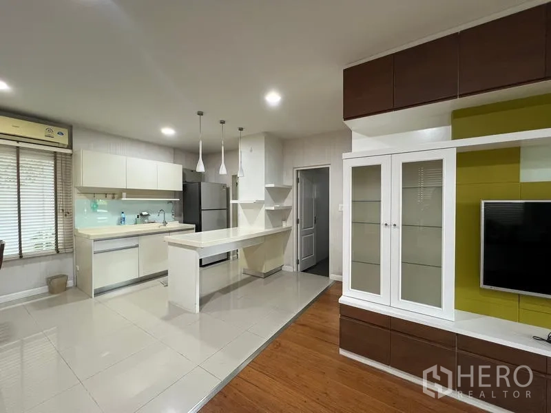 Detached House for rent in Bang Kapi, Bangkok - Open-plan kitchen and living area with TV unit and breakfast island.