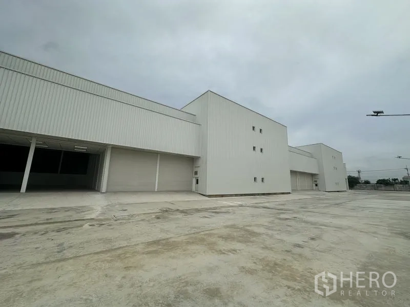 工厂 出租在Pathum Thani - 仓库侧立面，配大卷帘门与卡车通道。