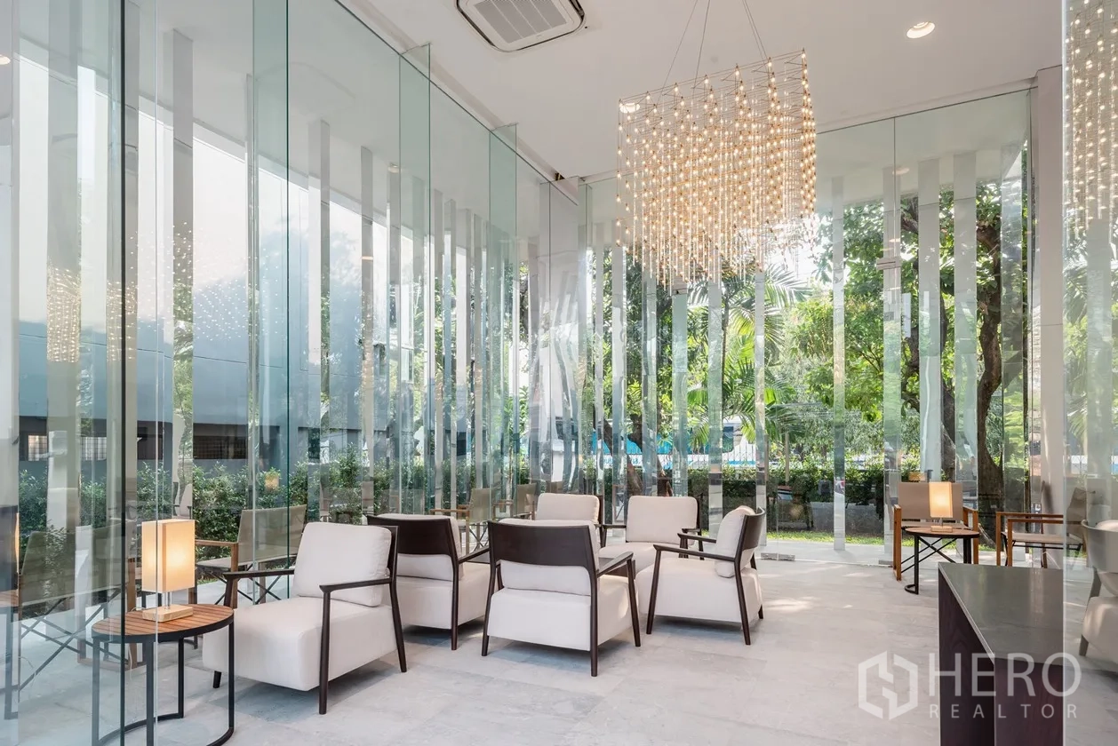 房间 出租在Khlong Toei, Bangkok - 玻璃幕墙大堂休息区，水晶吊灯与花园景观。
