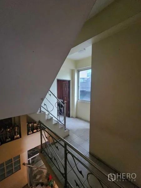 店屋 出租在Bang Rak, Bangkok - 室内楼梯与金属扶手，通往带窗的楼梯平台