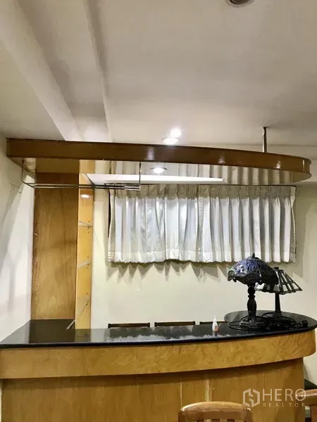 公寓 出租在Watthana, Bangkok - 带黑色石材台面的吧台区，顶部设吊灯照明。