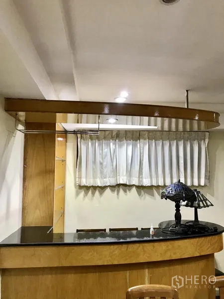 公寓 出租在Watthana, Bangkok - 带黑色石材台面的吧台区，顶部设吊灯照明。