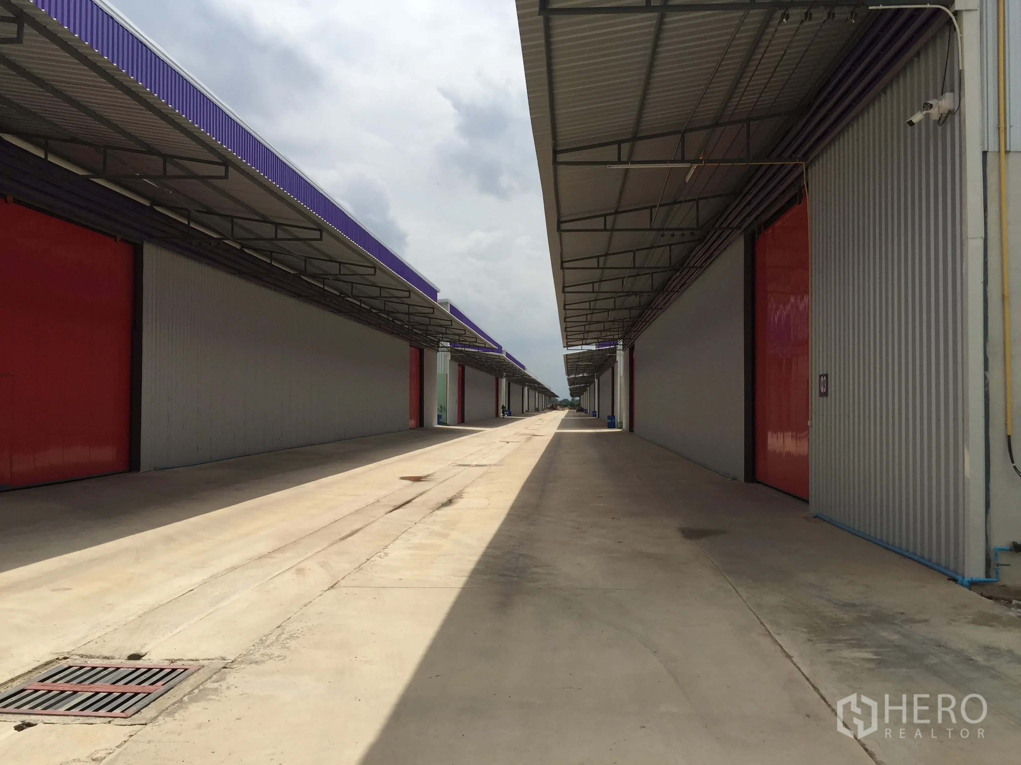Warehouse for rent in Pathum Thani - Covered loading lane between warehouses with CCTV and wide access for trucks.