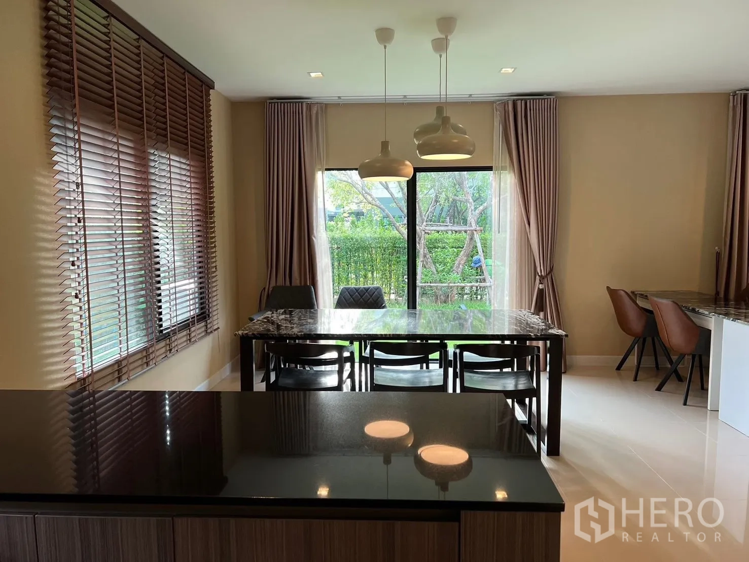 บ้าน ให้เช่าในBang Phli, Samut Prakan - พื้นที่รับประทานอาหารมองจากไอแลนด์ครัว มีโคมแขวน โต๊ะท็อปหิน มองเห็นสวน