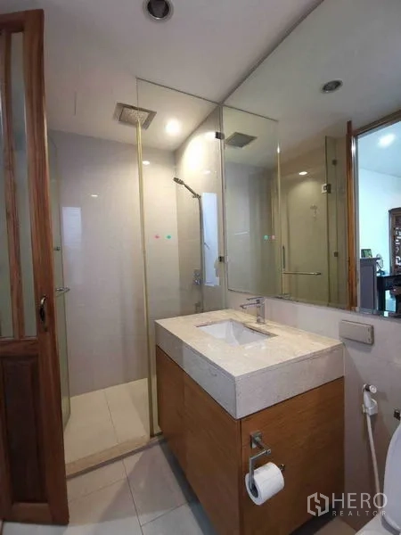 公寓 出租或出售在Bang Rak, Bangkok - 现代浴室，玻璃淋浴间配顶喷花洒与石质台盆。