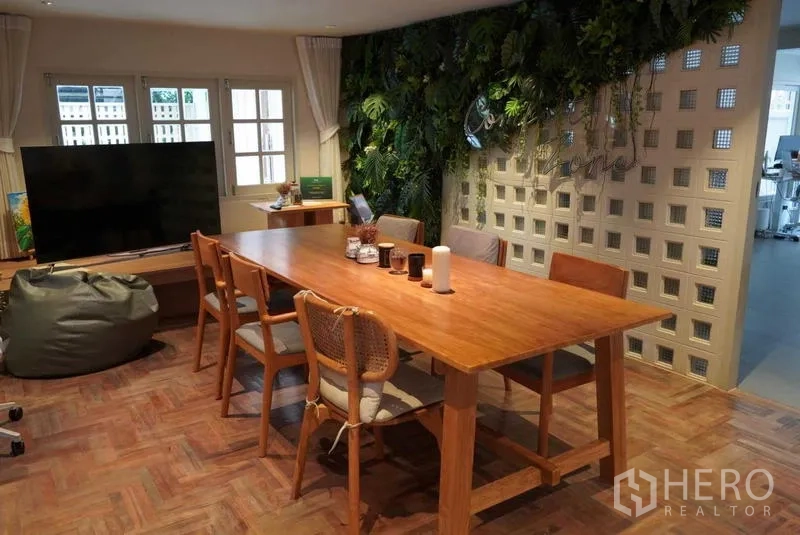 Detached House for rent in Watthana, Bangkok - Cozy dining or meeting area with long wooden table and green wall.