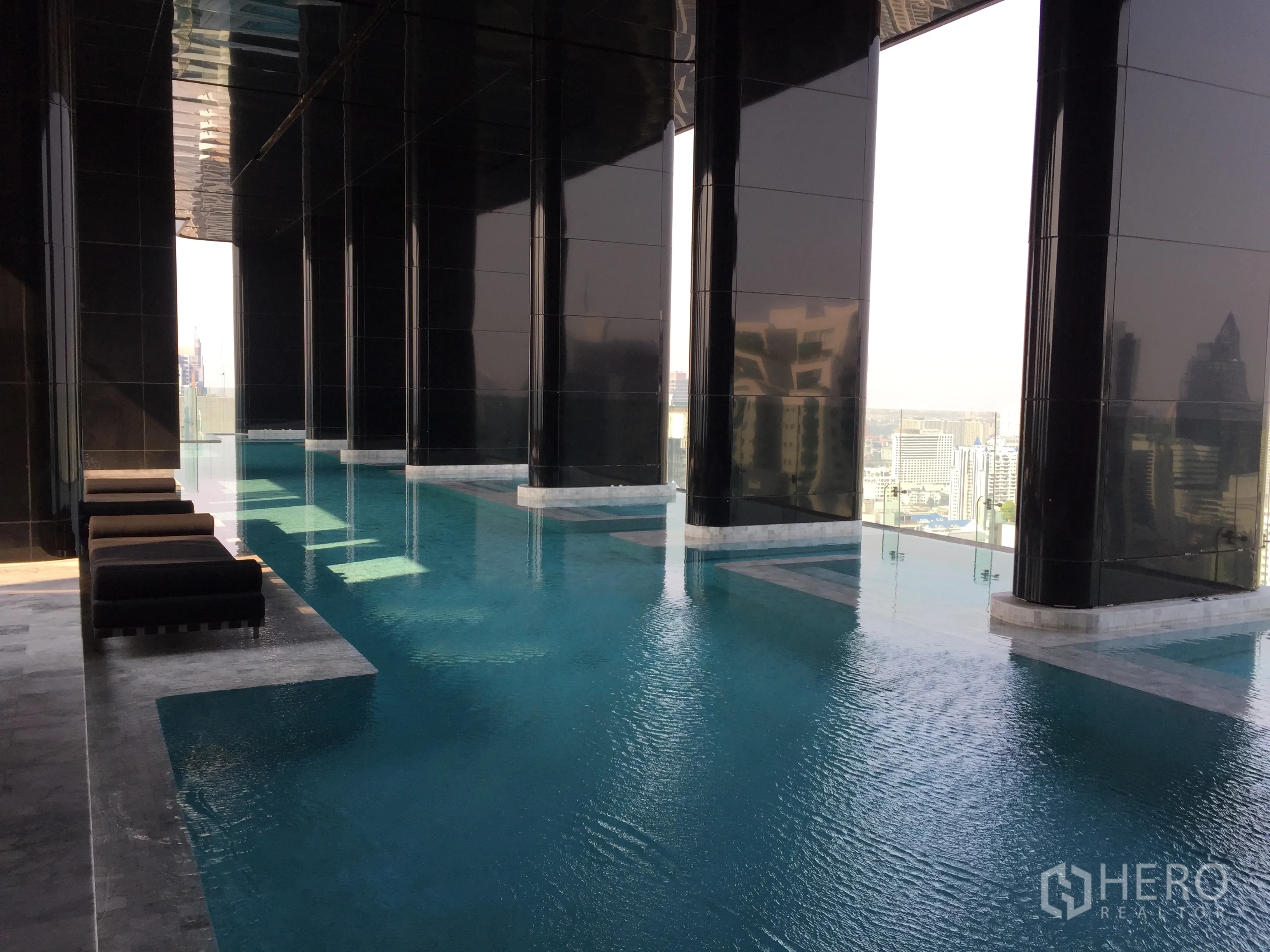 公寓 出售在Watthana, Bangkok - 高楼无边际泳池，躺椅与城市天际线景色