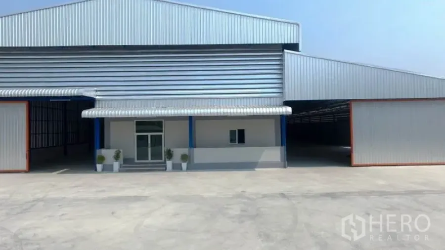 โรงงาน ให้เช่าในMueang Samut Sakhon, Samut Sakhon - ด้านหน้าโรงงานโครงสร้างเมทัลชีท ลานคอนกรีตกว้างและทางเข้าใต้กันสาด