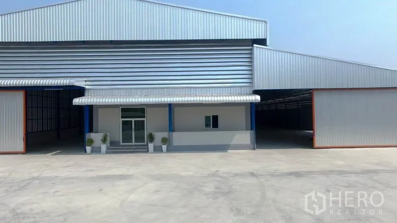 โรงงาน ให้เช่าในMueang Samut Sakhon, Samut Sakhon - ด้านหน้าโรงงานโครงสร้างเมทัลชีท ลานคอนกรีตกว้างและทางเข้าใต้กันสาด