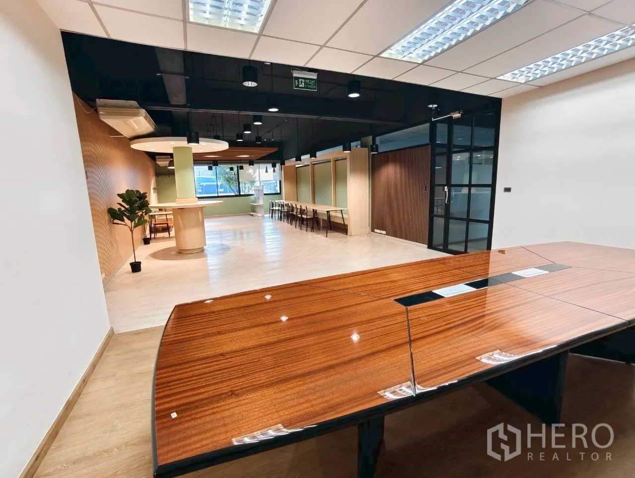 独立物业 for rent in Lak Si, Bangkok - 现代休闲洽谈区，木质桌面、黑色吊顶与玻璃门。