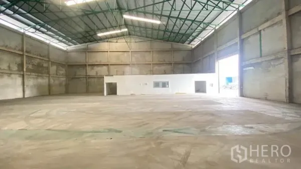 货栈 出租在Samut Prakan - 高挑仓库大厅，大型卷门与相连的办公室区。