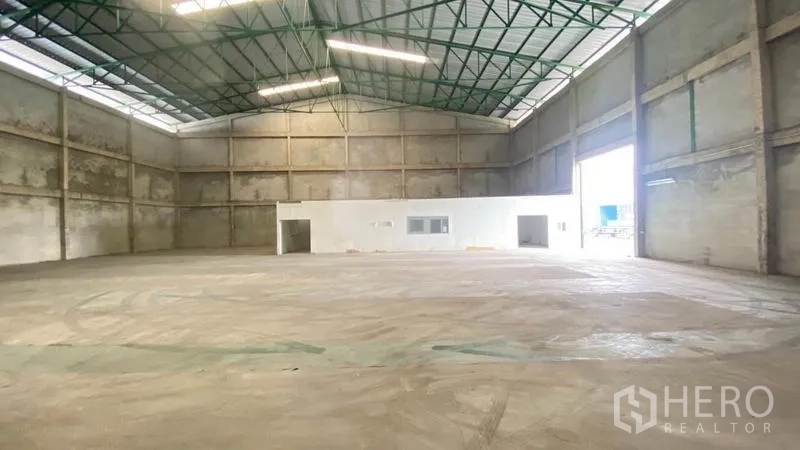 货栈 出租在Samut Prakan - 高挑仓库大厅，大型卷门与相连的办公室区。