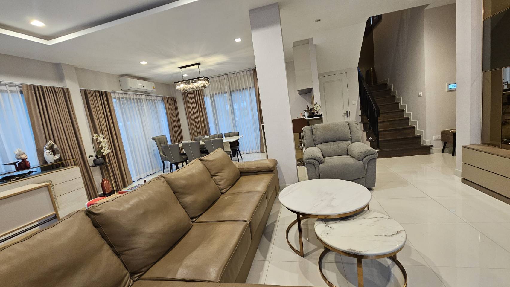 Detached House for rent in Saphan Sung, Bangkok - Open living area connecting to dining space and staircase with glossy tile floors.