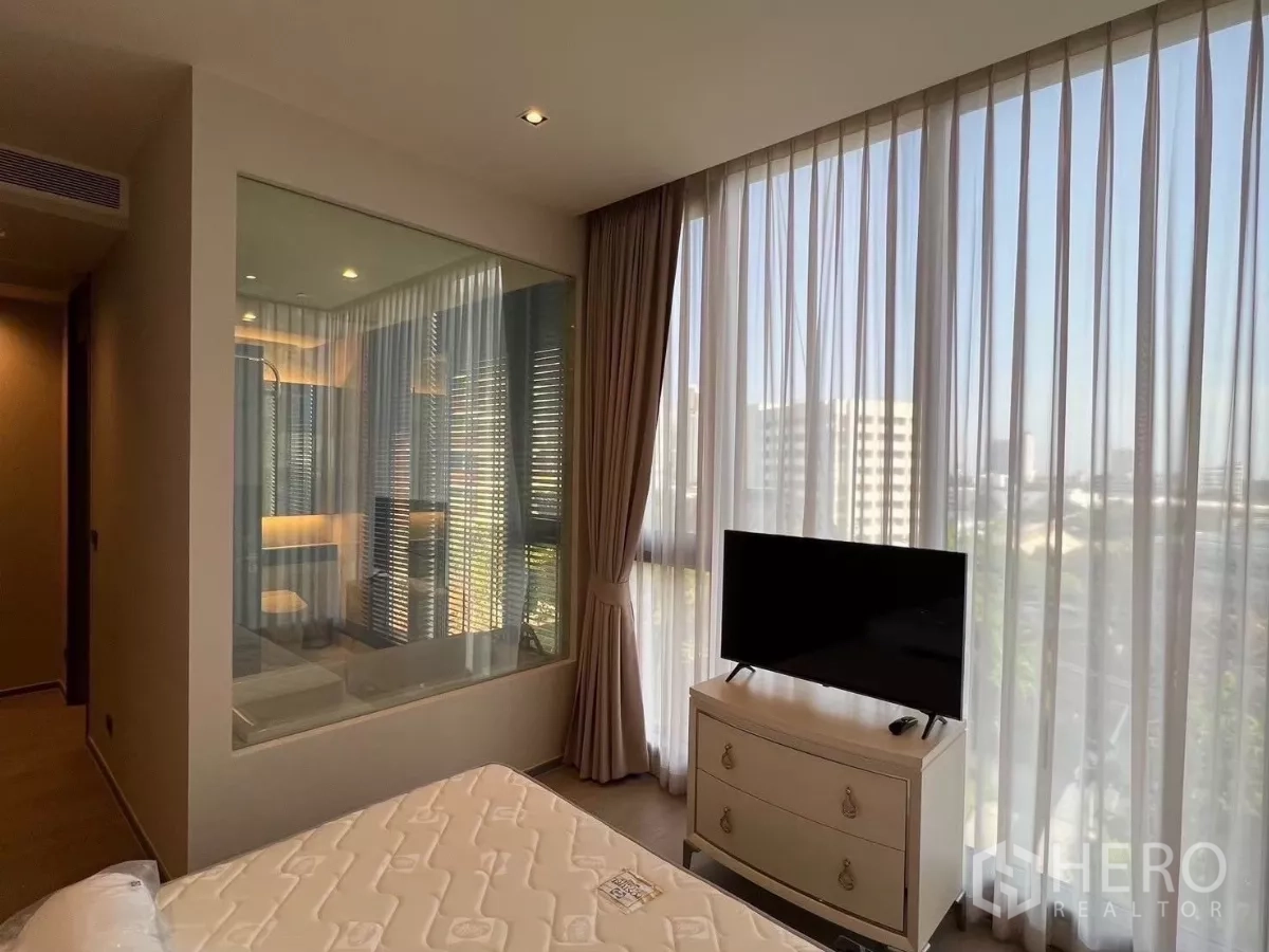 คอนโด ให้เช่าในWatthana, Bangkok - ห้องนอนมาสเตอร์มองเห็นวิวเมืองผ่านผ้าม่านสูงจรดเพดานและผนังกระจกติดห้องน้ำ