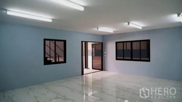 Warehouse for rent in Bueng Kum, Bangkok - Ground-floor office or meeting room with marble-look tiles, multiple windows and fluorescent lighting.