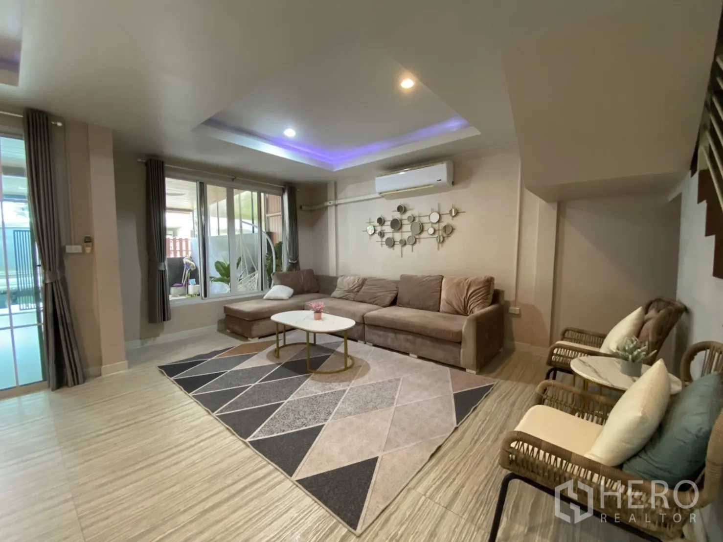 Townhouse for rent or sale - Spacious lounge with L-shaped sofa, large window and air conditioner.