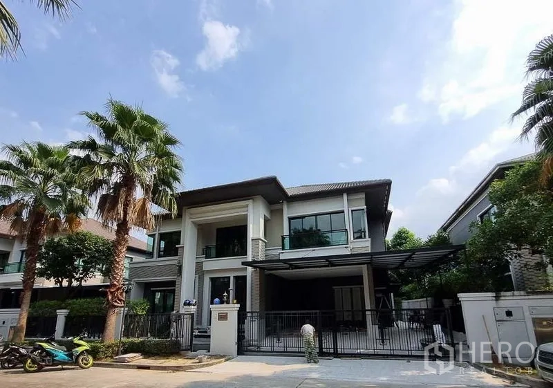 Detached House for rent in Bang Khae, Bangkok - Front elevation of a contemporary detached house with gated entrance and carport.
