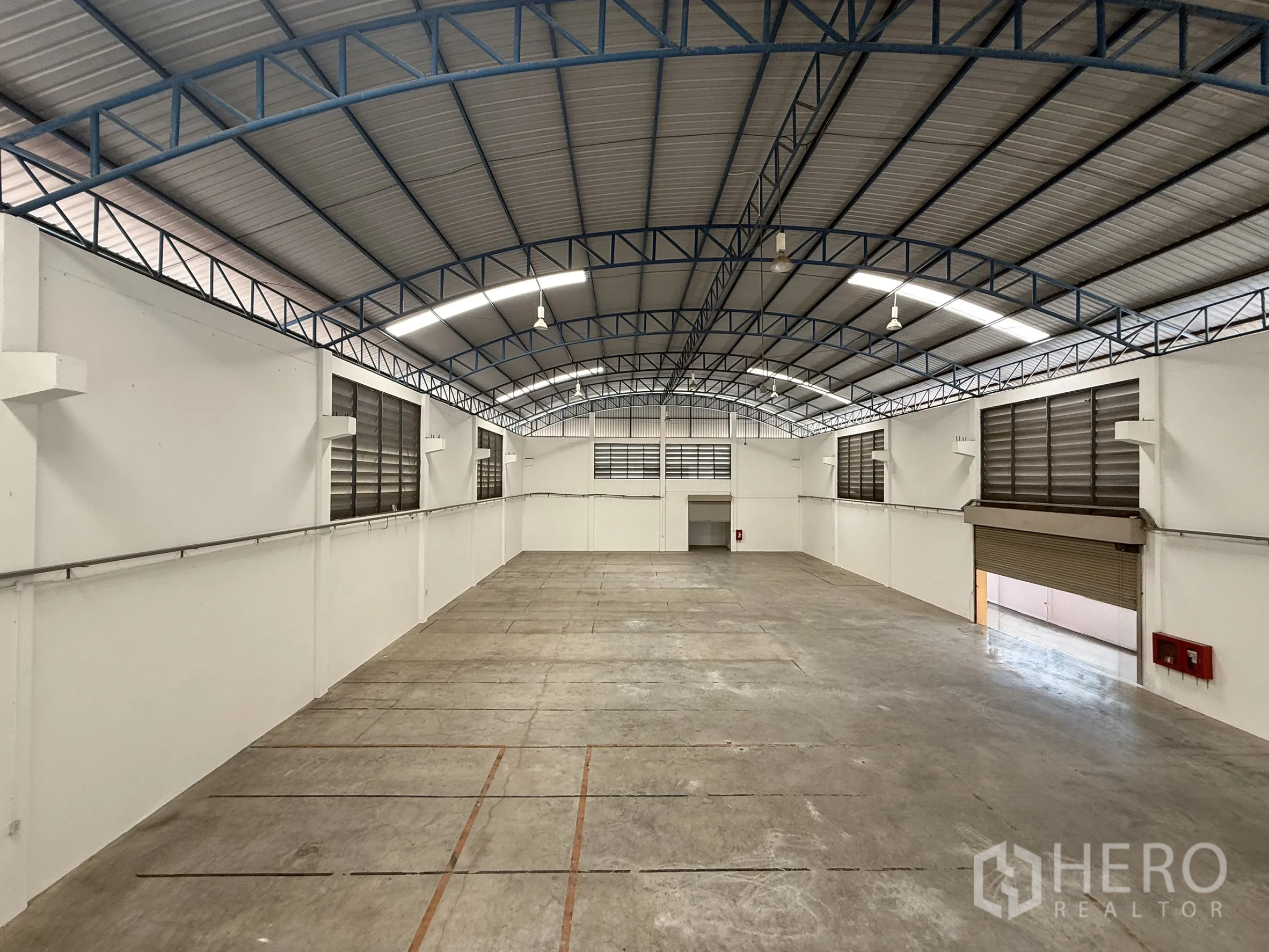 Warehouse for rent or sale in Bang Bo, Samut Prakan - Clean warehouse interior with high arched steel roof, skylights and smooth concrete floor.