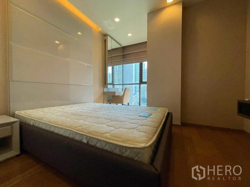 公寓 出租在Bang Rak, Bangkok - 主卧配大床与特色墙，窗边书桌