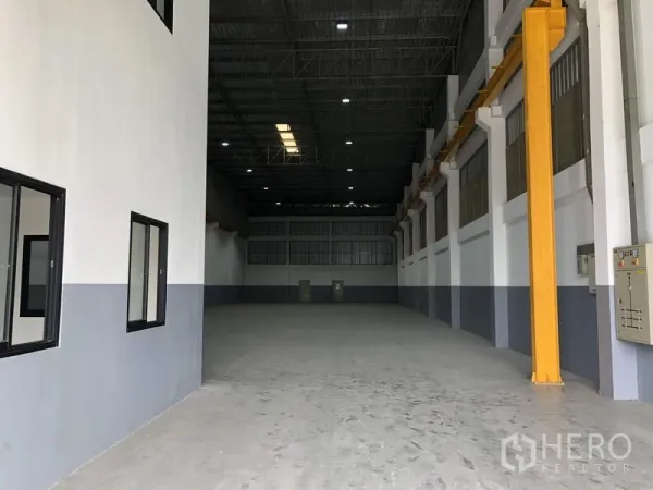 Factory for rent or sale in Bang Phli, Samut Prakan - High-clearance production hall with steel roof, skylight panels, and crane runway beams along the wall.