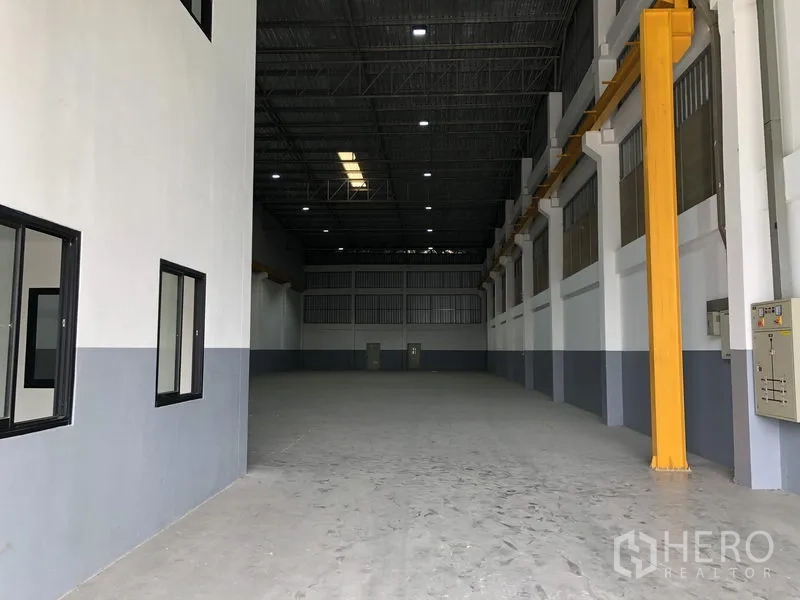 Factory for rent or sale in Bang Phli, Samut Prakan - High-clearance production hall with steel roof, skylight panels, and crane runway beams along the wall.