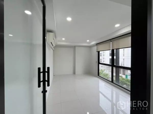 办公空间 出租在Prawet, Bangkok - 明亮办公室，玻璃门、白色瓷砖地面，落地窗配卷帘。