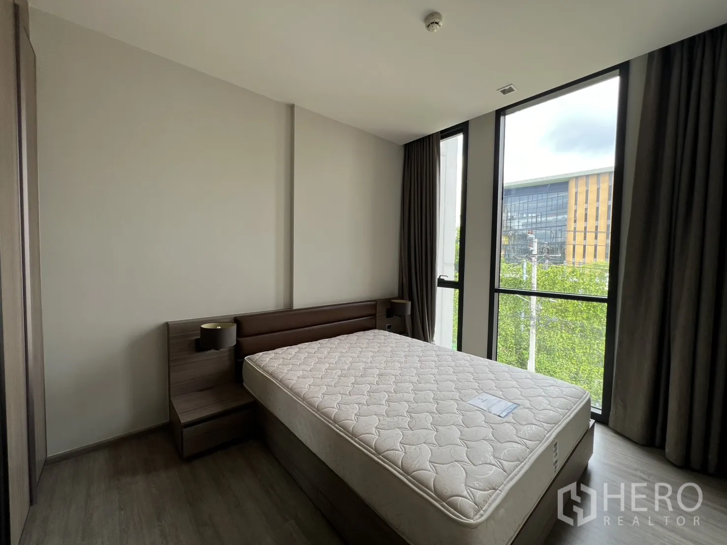 คอนโด for rent in Watthana, Bangkok - ห้องนอนเตียงขนาดใหญ่ หน้าต่างบานสูง และวิวต้นไม้