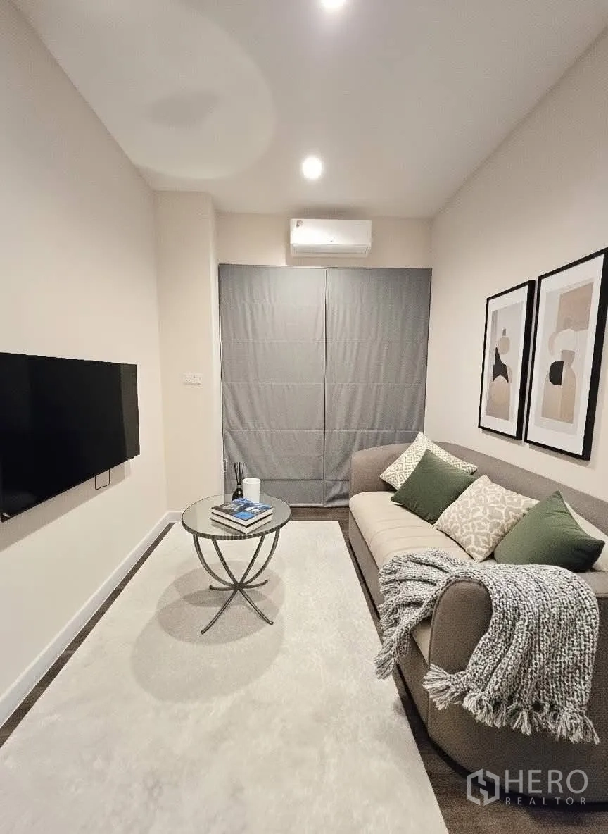 บ้าน for rent or sale in Bang Phli, Samut Prakan - ห้องนั่งเล่นขนาดกะทัดรัด โซฟา โต๊ะกลางทรงกลม ทีวีติดผนัง และกรอบภาพ