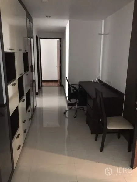 公寓 出租在Watthana, Bangkok - 走廊工作区，带内置书架与书桌，亮面地砖，动线通往卧室。