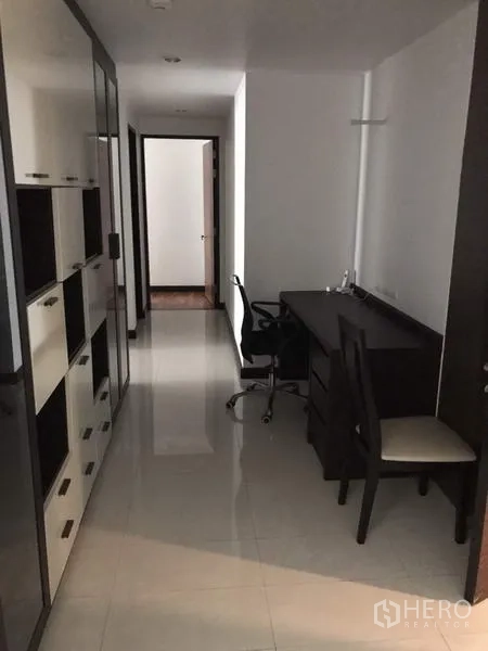 公寓 出租在Watthana, Bangkok - 走廊工作区，带内置书架与书桌，亮面地砖，动线通往卧室。
