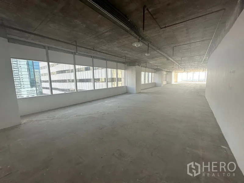 Office Space for rent in Watthana, Bangkok - Elongated workspace lined with continuous windows providing abundant natural light.