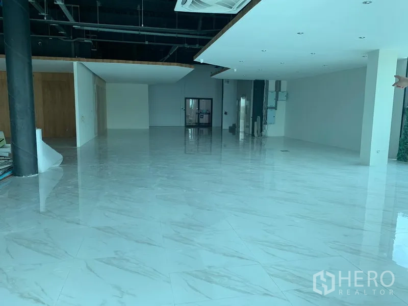 Retail Space for rent in Lam Luk Ka, Pathum Thani - Spacious open-plan retail floor with glossy marble tiles, high ceilings and recessed lighting.