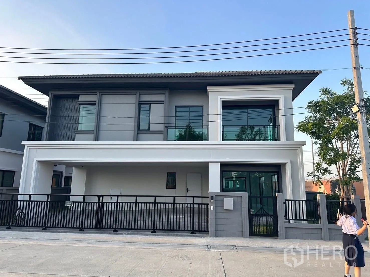 独栋房屋 for rent in Bang Phli, Samut Prakan - 两层现代独栋别墅外观，玻璃阳台，带院墙与有顶车位。