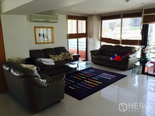 Condominium for rent in Bang Rak, Bangkok - Bright corner lounge with leather sofas, wide windows, balcony and city views.