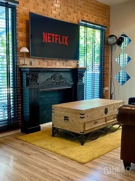 Detached House for rent in Saphan Sung, Bangkok - Close-up of decorative black mantel, wall-mounted TV and rustic coffee table.