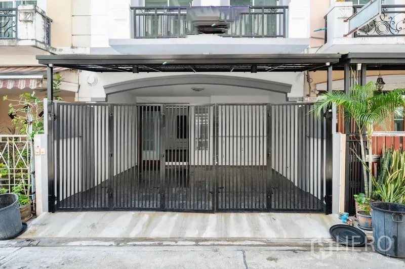 Townhouse for sale - Gated two-car carport at the front of the townhouse with metal sliding doors.