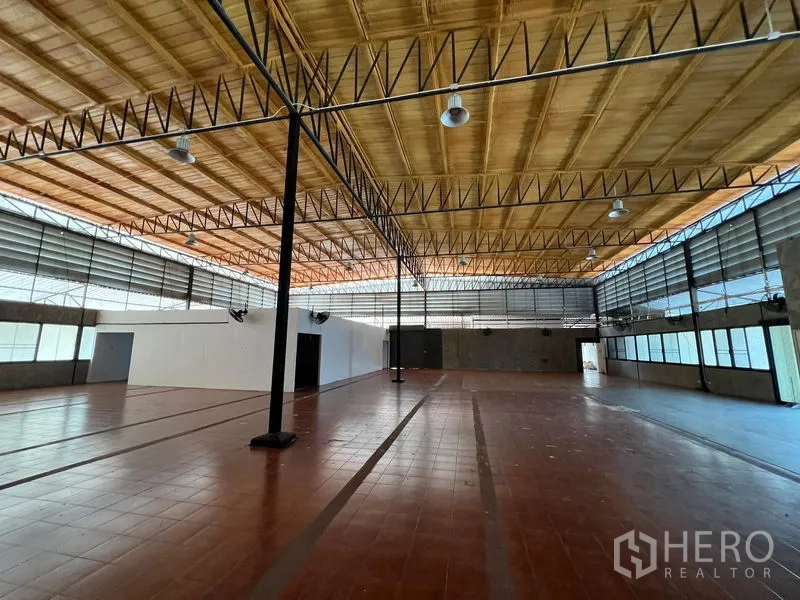 Warehouse for rent in Saphan Sung, Bangkok - High-ceiling warehouse floor with steel trusses and ventilated windows.