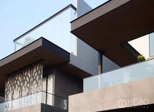 Detached House for sale in Lat Phrao, Bangkok - Modern detached house facade in Lat Phrao with glass balconies and warm wood soffits.