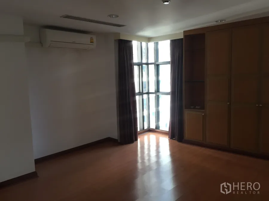 公寓 出租在Pathum Wan, Bangkok - 帕吞旺公寓内的转角卧室，落地窗、内置衣柜与木地板，采光充足。
