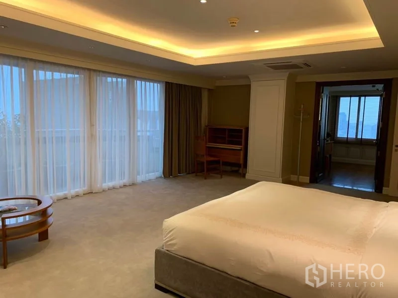 Condominium for rent or sale in Watthana, Bangkok - Spacious master bedroom with floor-to-ceiling curtains, cove lighting and ensuite access.