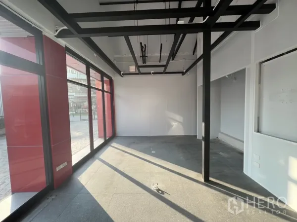 零售空间 出租 - 角落展示区，大面积玻璃与外露吊顶格栅。