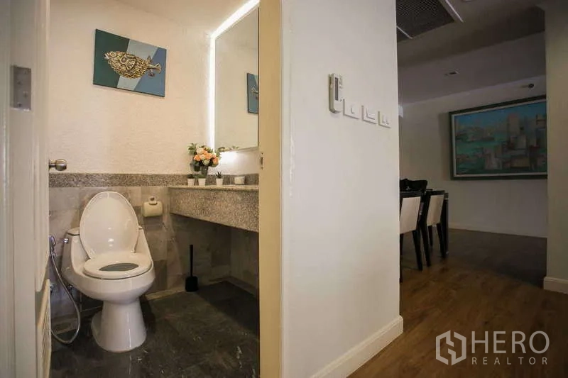 Condominium for rent or sale in Watthana, Bangkok - Guest powder room with granite countertop, illuminated mirror and toilet.
