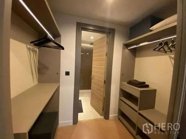 公寓 出售在Bang Rak, Bangkok - 步入式衣帽间，开放式层架与挂衣区，通往现代化浴室。